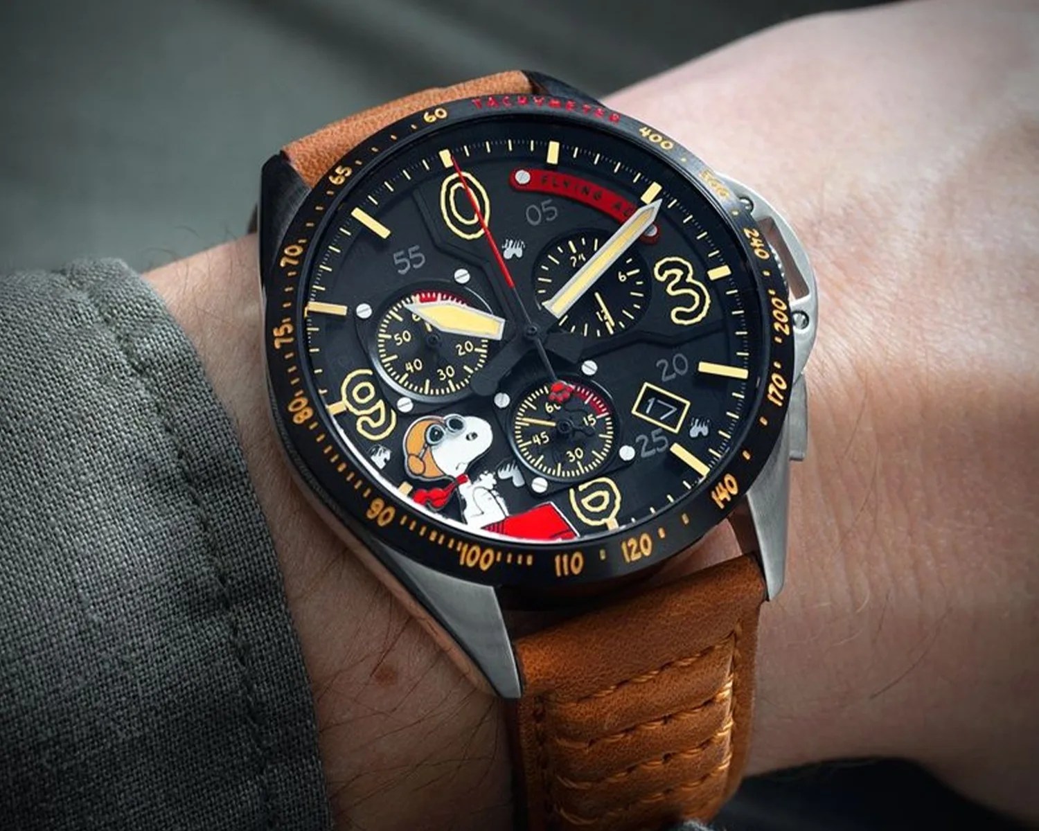 an avi 8 snoopy watch on a mans wrist
