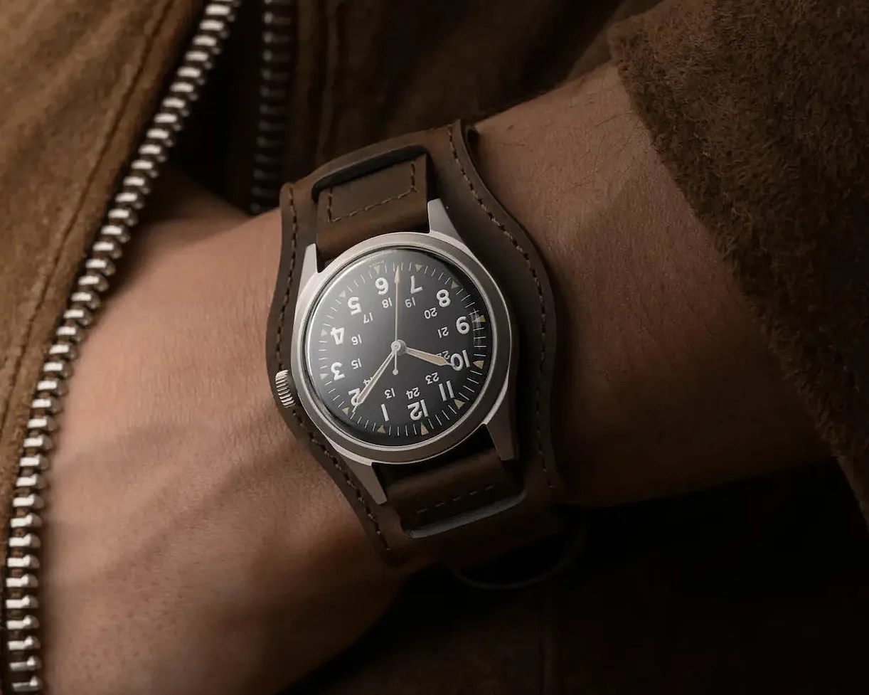 a Benrus field watch on a man's wrist