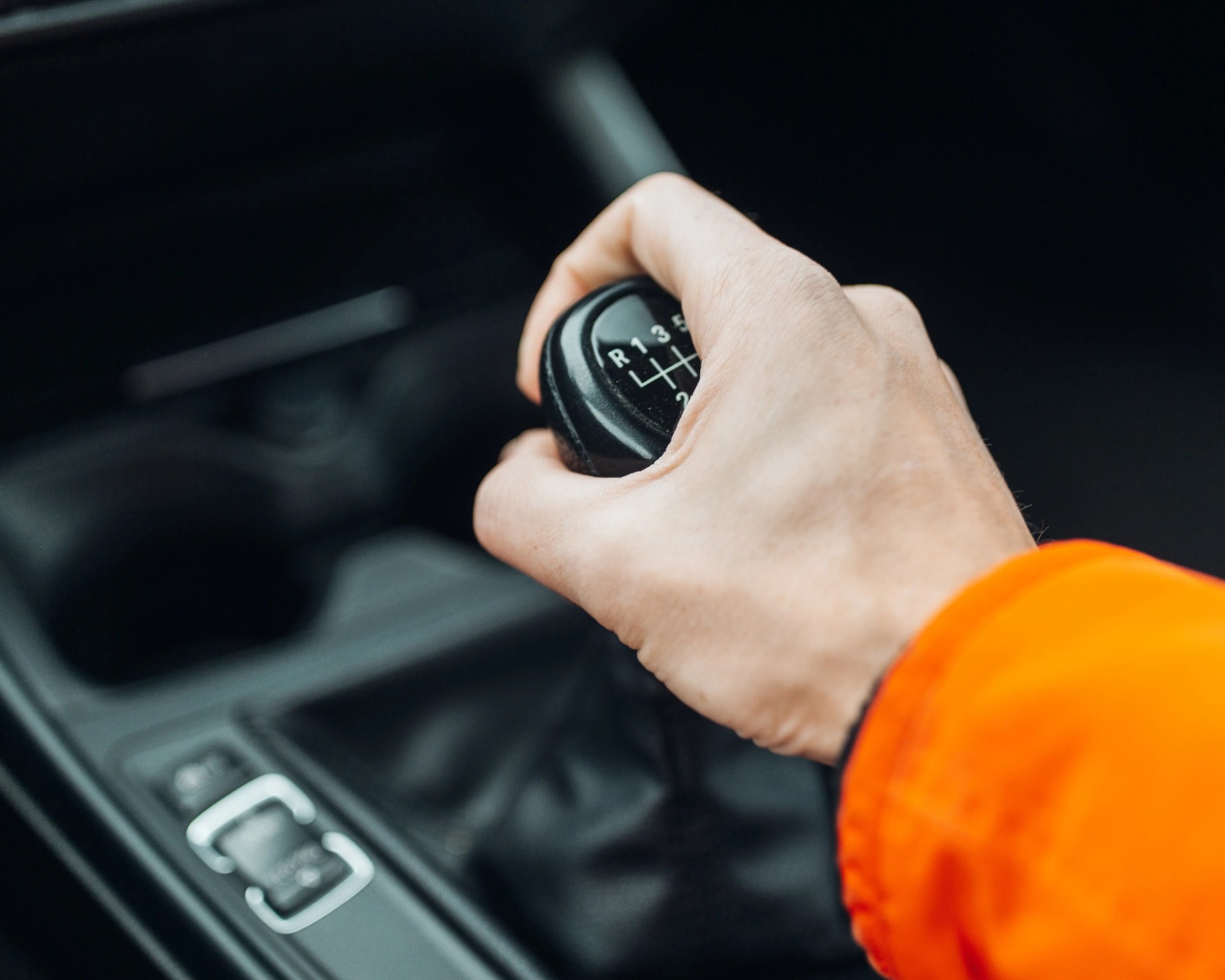 a photo of a hand holding the shifter for a manual transmission