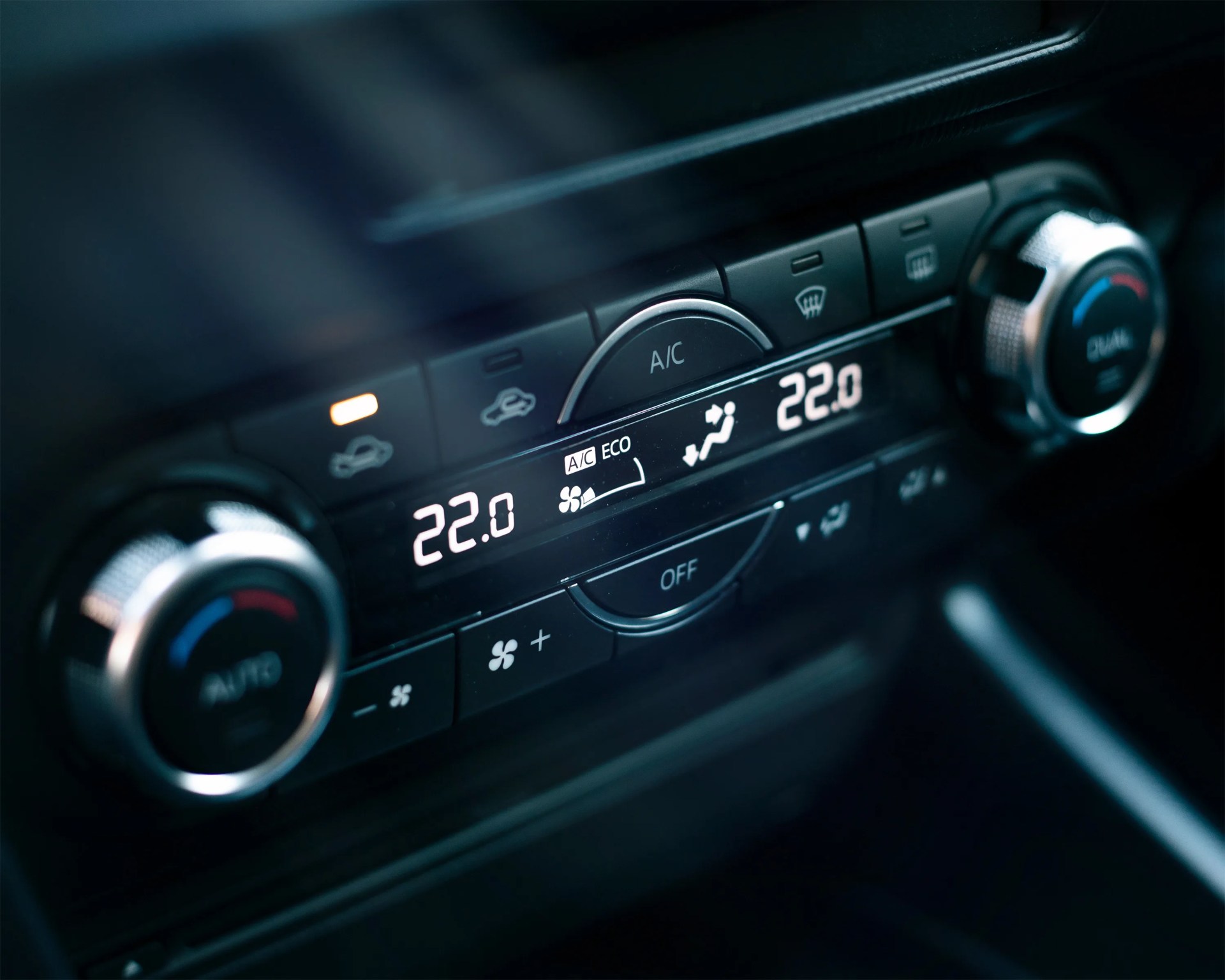 a photo of a climate control interface with physical buttons