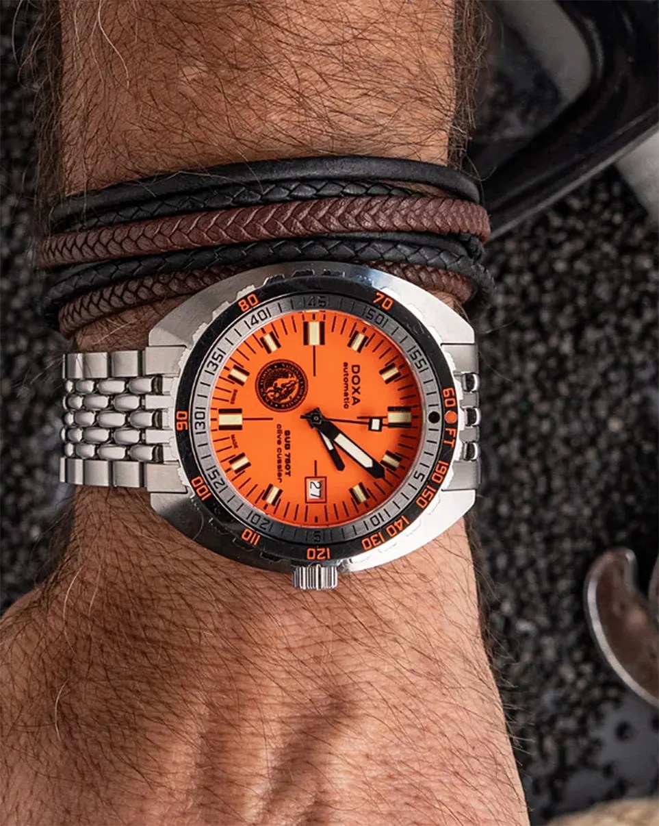 a an wearing an orange Doxa dive watch