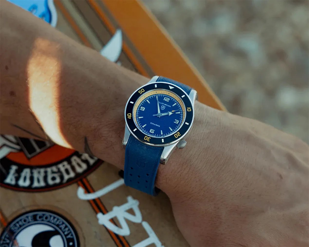 a blue elliot brown dive watch on a man's wrist