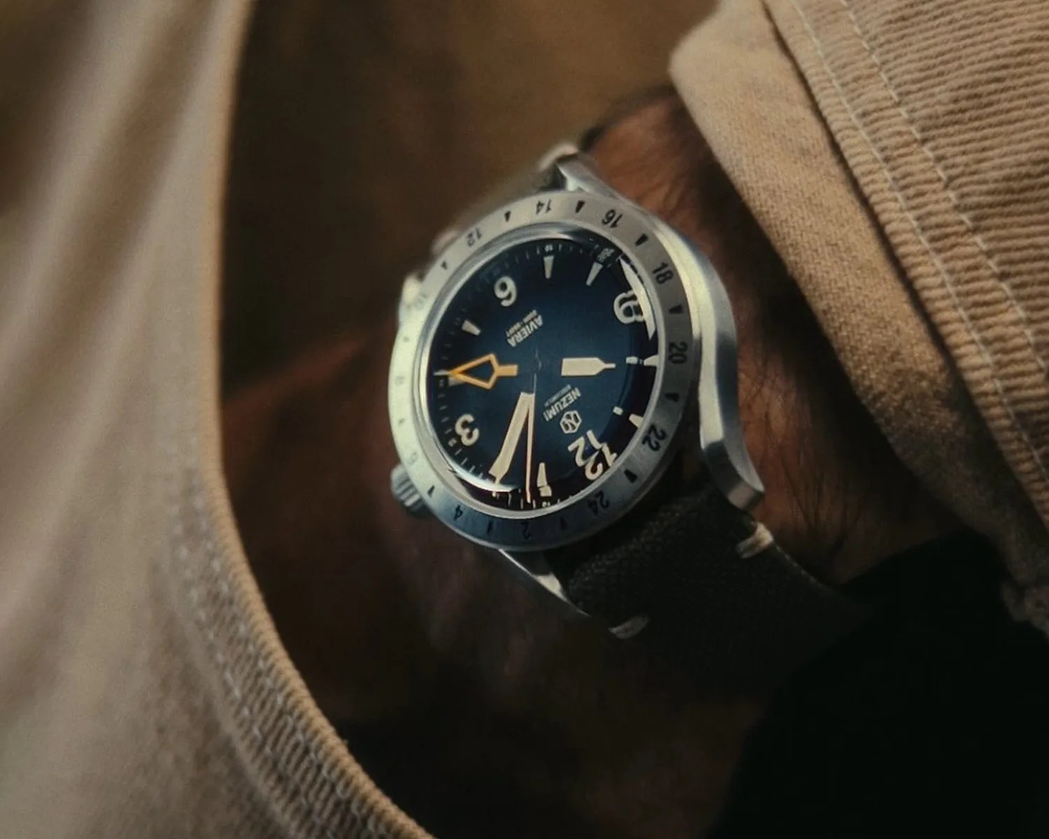 a nezumi gmt watch on a mans wrist