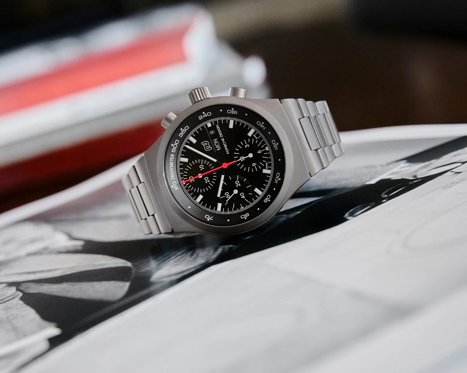 a porsche design chronograph watch on a book