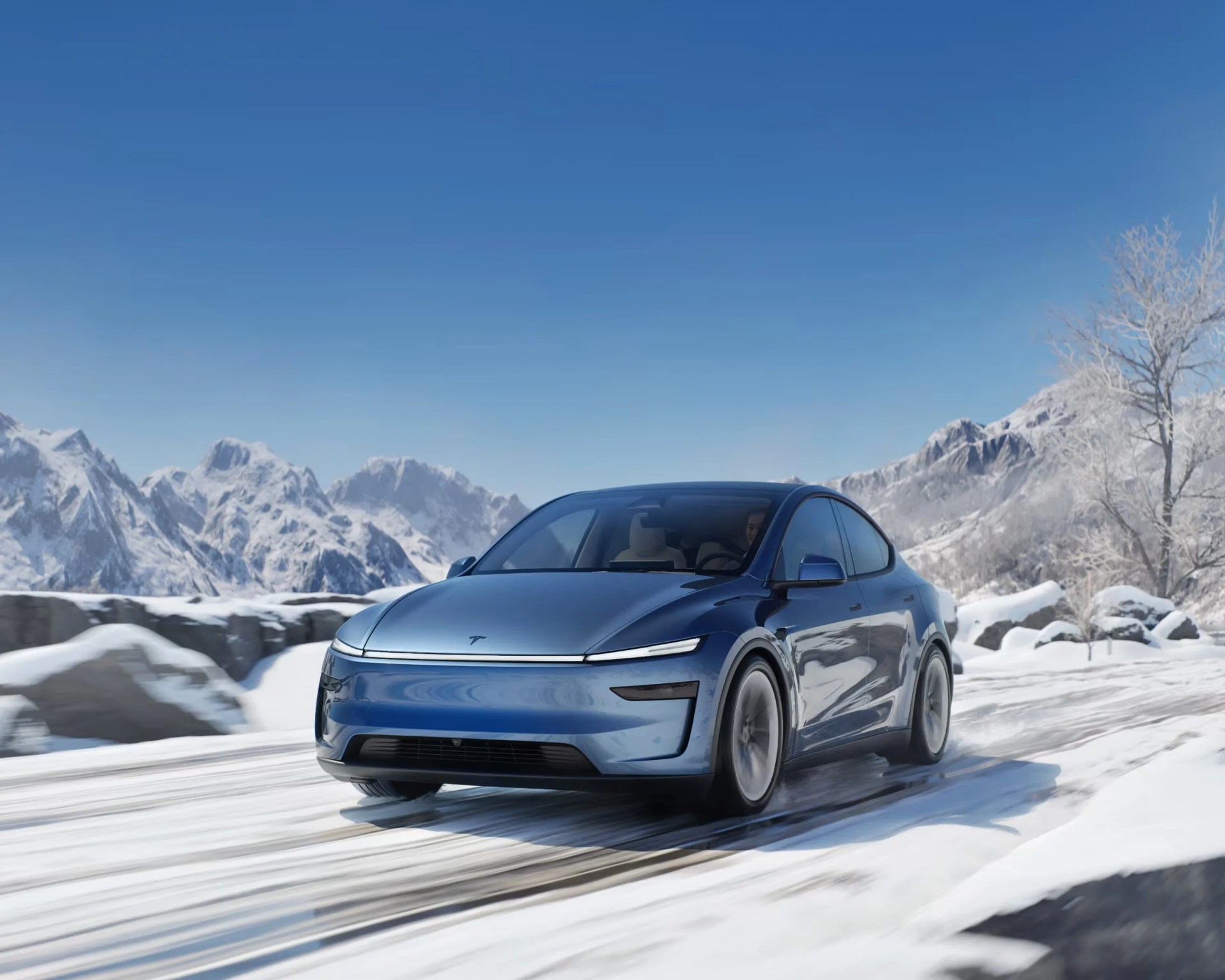 blue tesla model y driving on snow