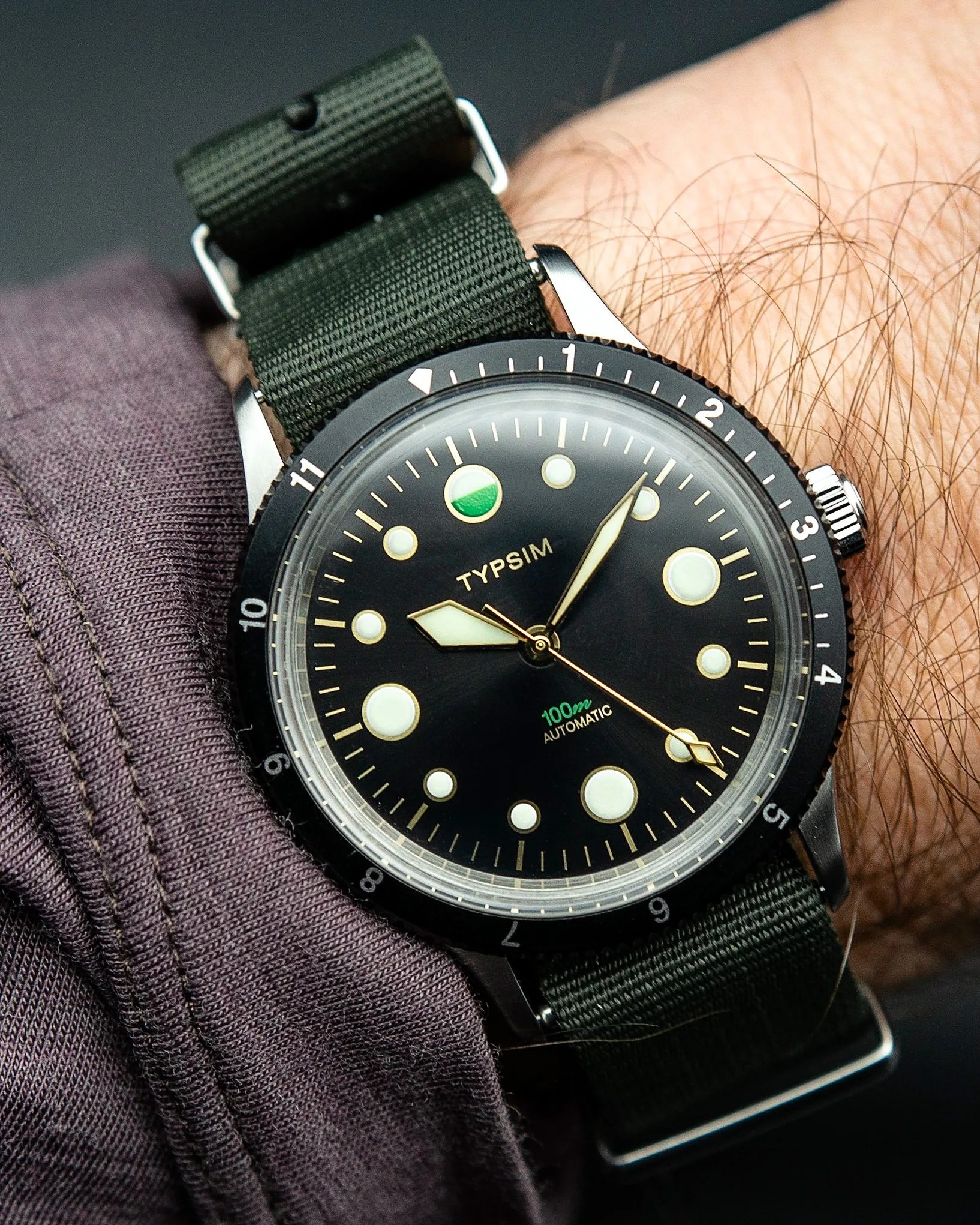 a black dive watch on a man's wrist