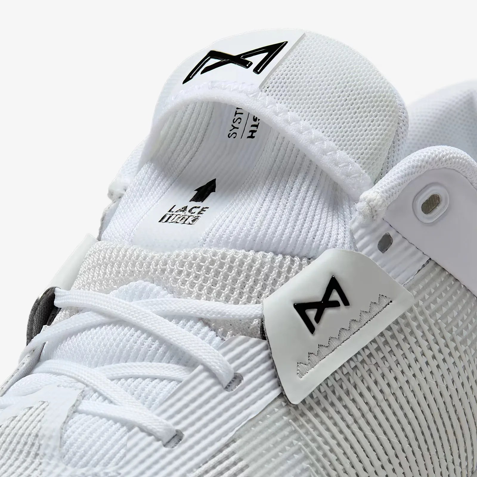 A close-up of the lace tuck pocket in the tongue of the Nike Metcon 10 gym shoe in white