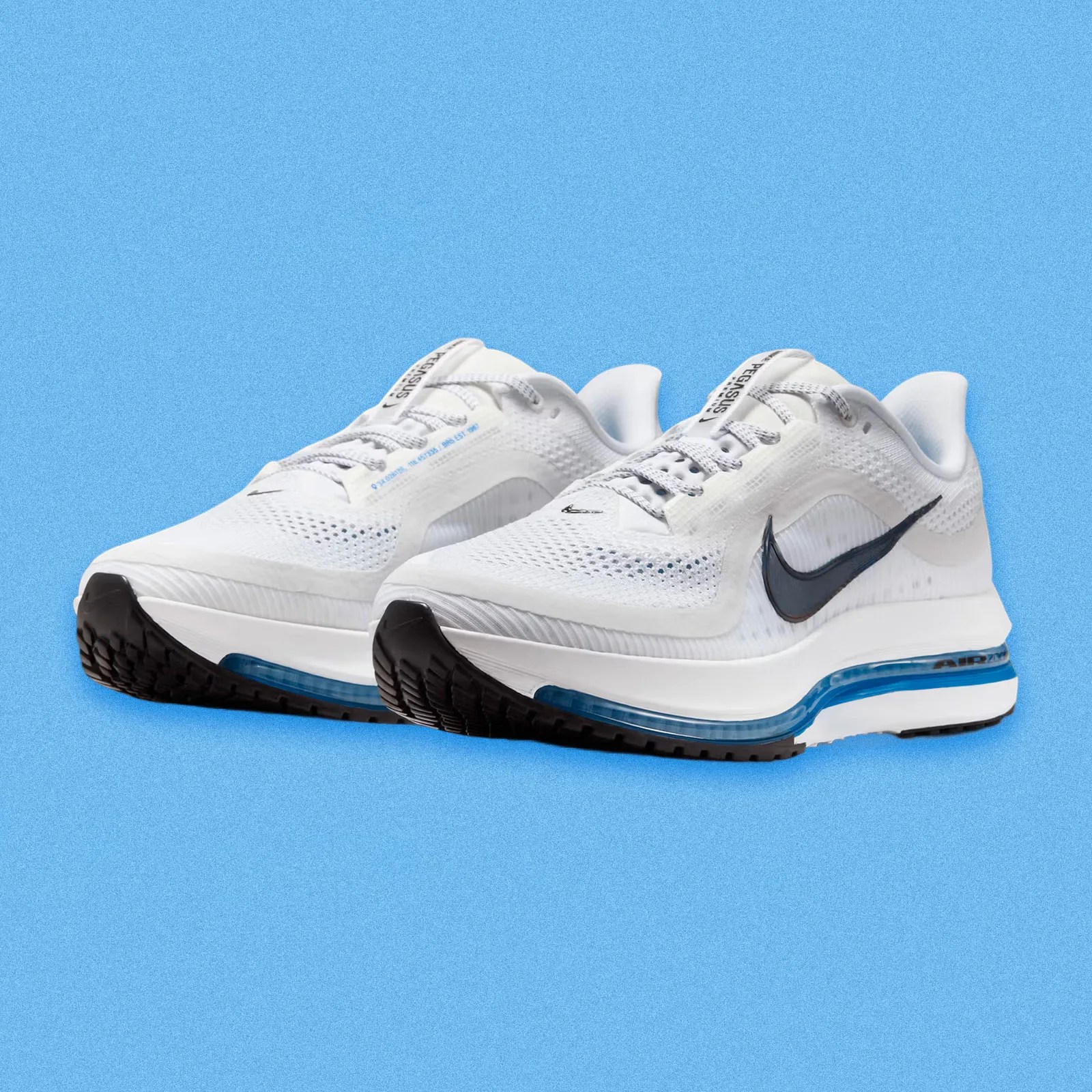 A pair of Nike Pegasus Premium in white and photo blue shown at an angle with the toes pointing to the left bottom corner