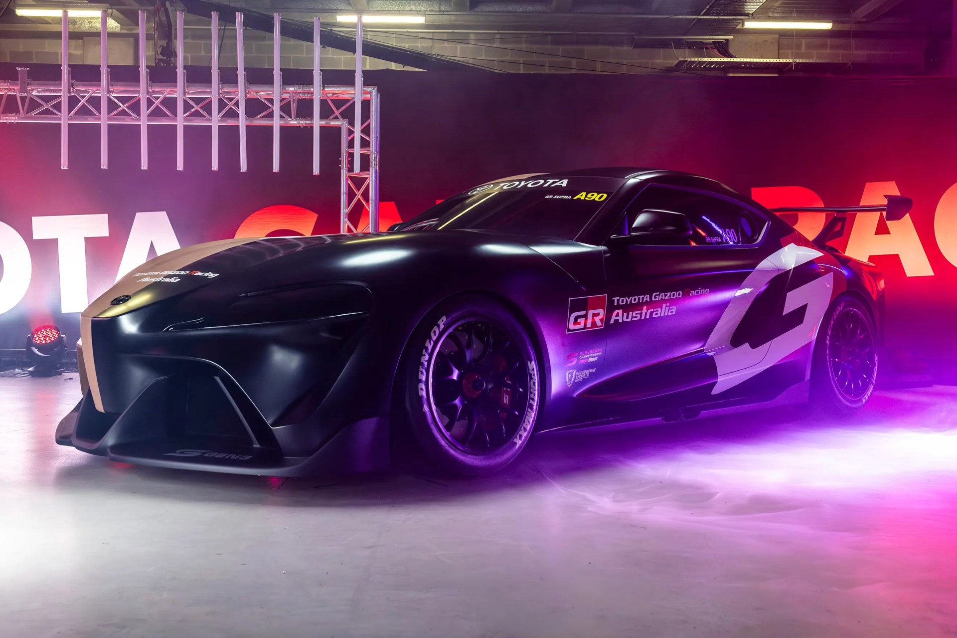 a photo of a toyota supra race car with fog and colored lights