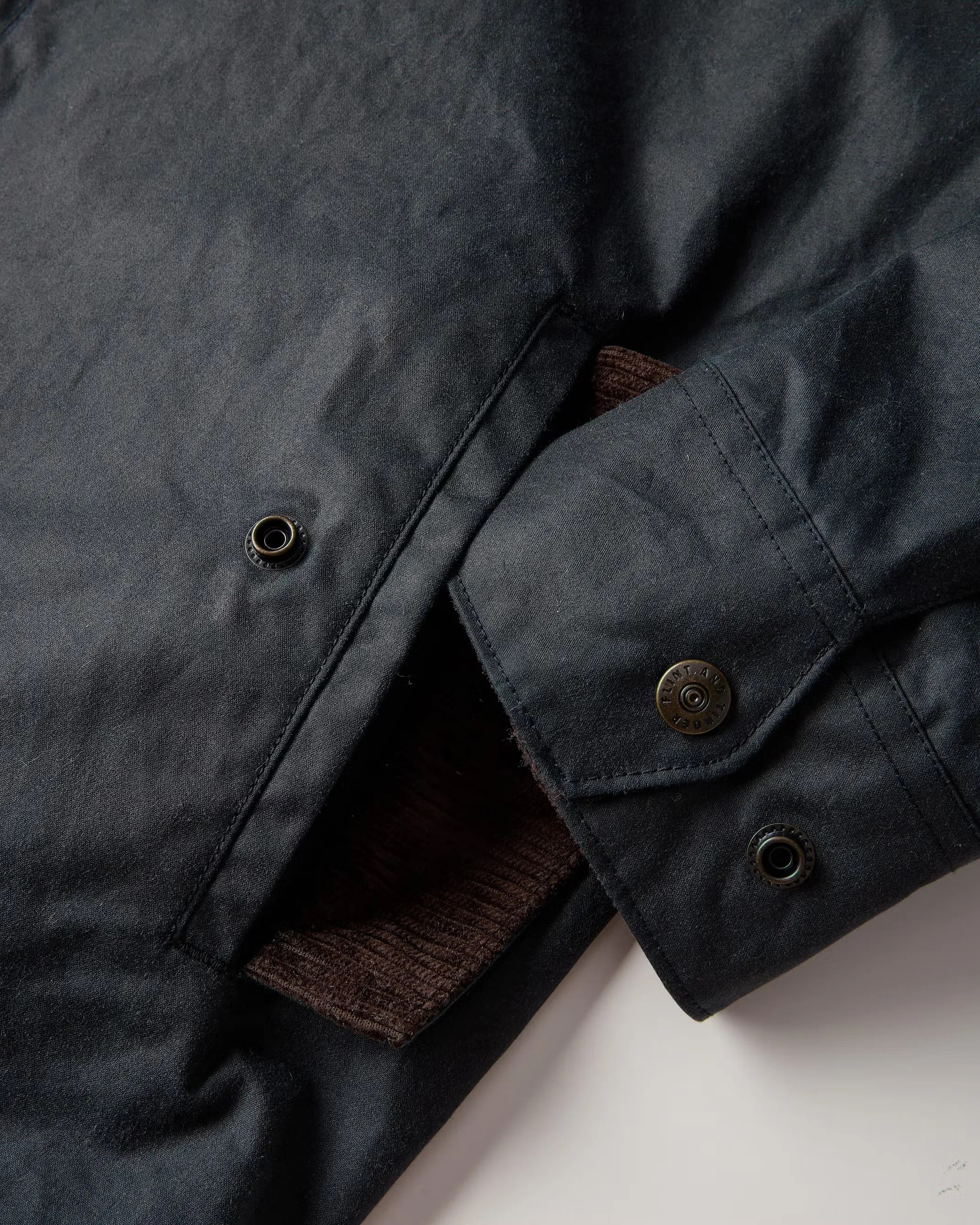 the cuff and pocket of a waxed harrington jacket