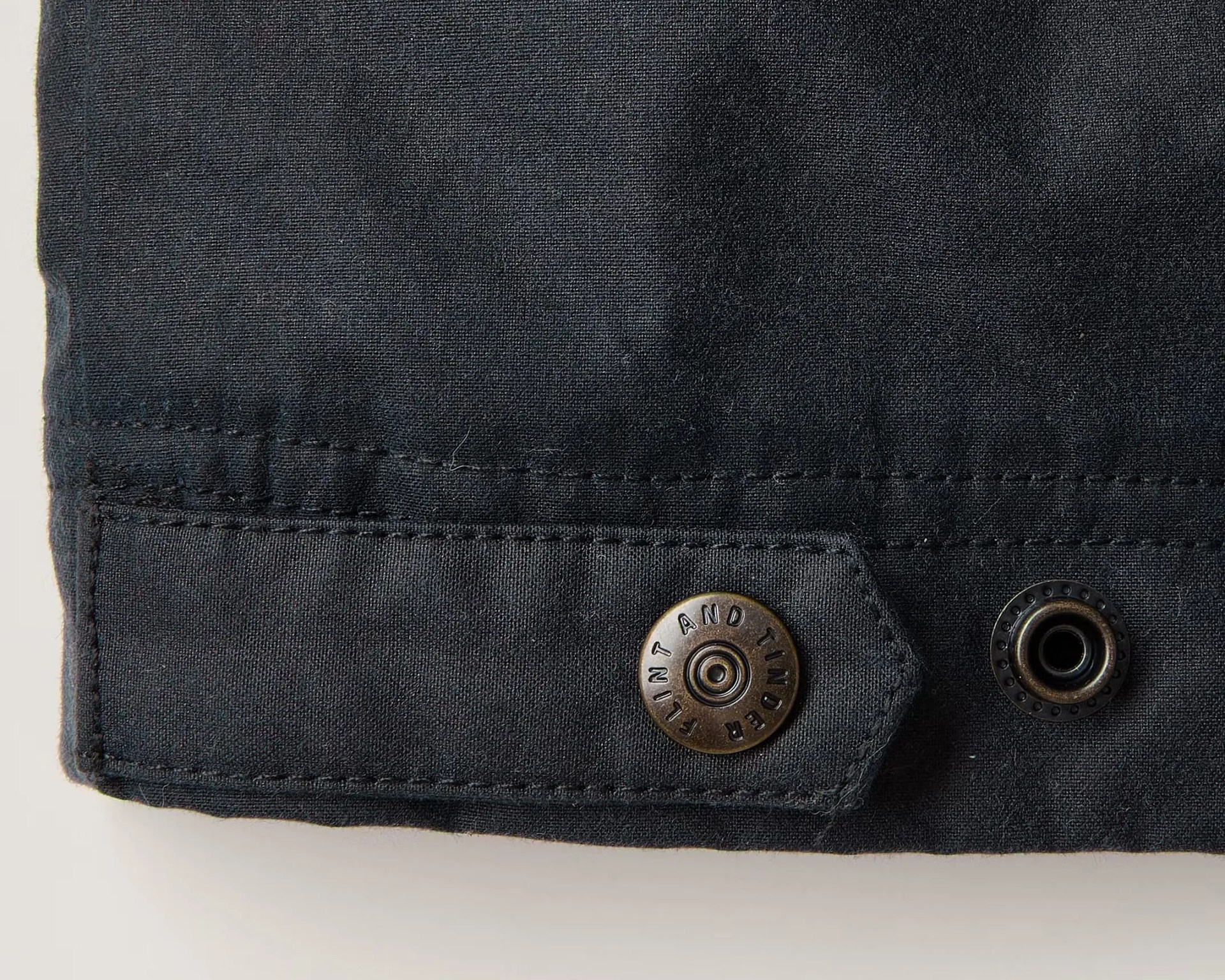 the waist tab of a waxed harrington jacket