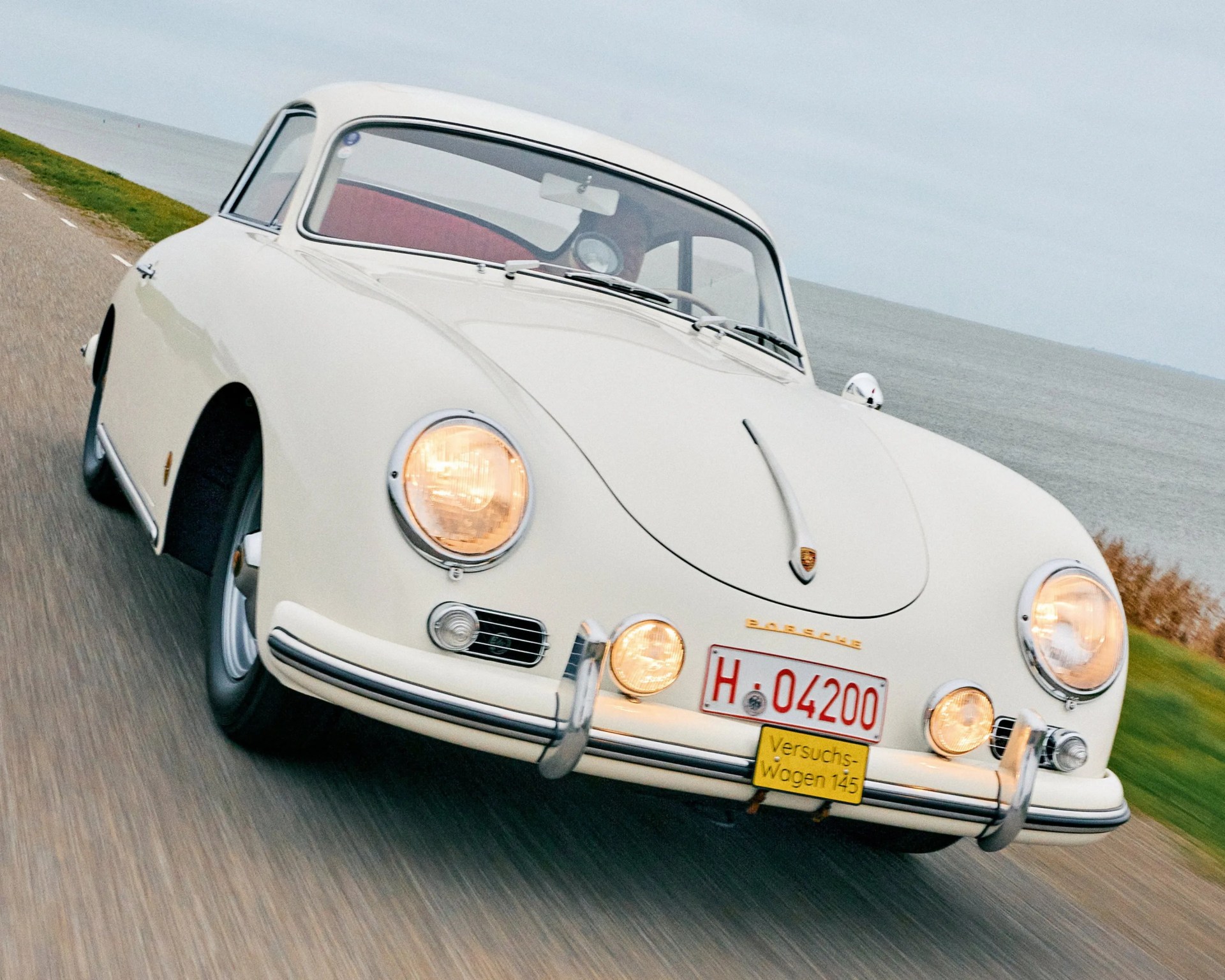 a photo of a classic porsche sport car driving
