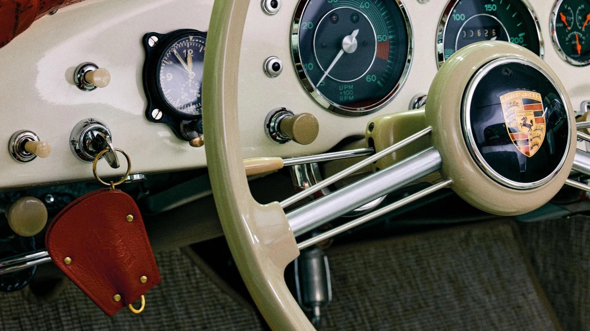 a close-up photo of a porsche steering wheel and key